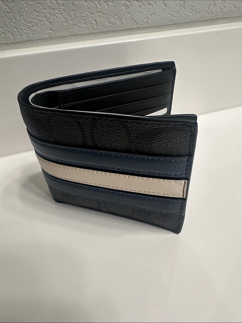 Coach Men's Black Signature Pattern Bifold Wallet with Blue and Cream Stripes